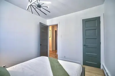 a bedroom with a bed and a green door at Sherby LUX - Central, Parking, Renovated, Sleeps 6 in Sherbrooke