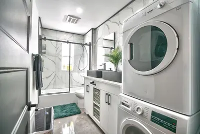 a bathroom with a washer and dryer in it at Sherby LUX - Central, Parking, Renovated, Sleeps 6 in Sherbrooke