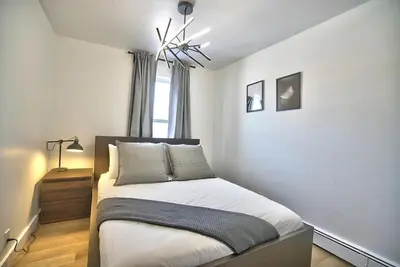 a bedroom with a bed and a window at Sherby LUX - Central, Parking, Renovated, Sleeps 6 in Sherbrooke