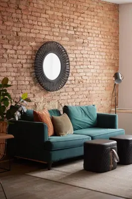 a living room with a blue couch and a brick wall at The Suzanne by Denstays in Montréal