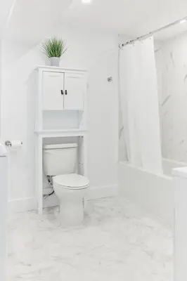 a white bathroom with a toilet and a shower at The Suzanne by Denstays in Montréal