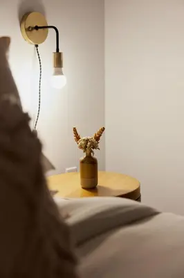 a room with a table with a lamp and a bed at The Suzanne by Denstays in Montréal