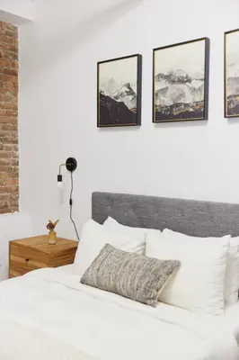 a bedroom with a white bed and pictures on the wall at The Suzanne by Denstays in Montréal