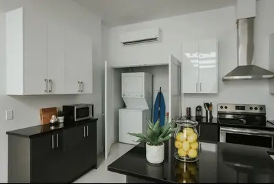 a kitchen with white cabinets and a black counter top at Stylish and bright 2bdr near St-Hubert Plaza in Montréal
