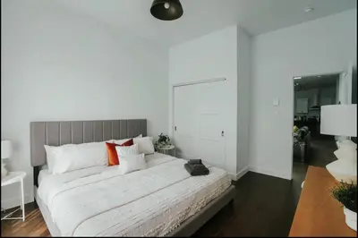 a bedroom with a large white bed with orange pillows at Stylish and bright 2bdr near St-Hubert Plaza in Montréal