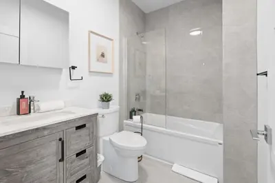 a bathroom with a toilet and a sink and a shower at Modern and Cozy 2bdr near St-Hubert Plaza in Montréal