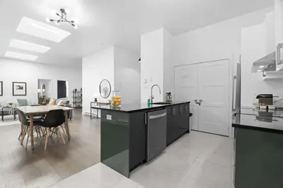 a kitchen with black and white appliances and a table at Modern and Cozy 2bdr near St-Hubert Plaza in Montréal