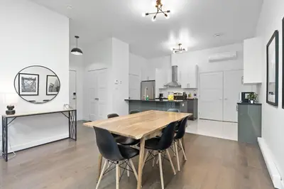 a kitchen and dining room with a wooden table and chairs at Modern and Cozy 2bdr near St-Hubert Plaza in Montréal