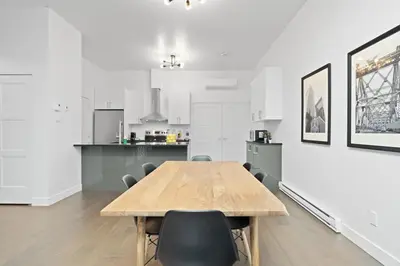 a kitchen and dining room with a wooden table and chairs at Modern and Cozy 2bdr near St-Hubert Plaza in Montréal