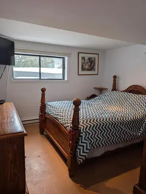 a bedroom with a bed and a television in it at Style Chalet in Montréal