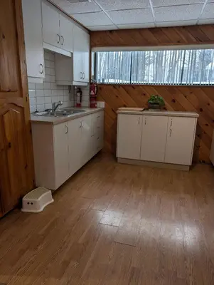 a kitchen with white cabinets and a sink in a room at Style Chalet in Montréal