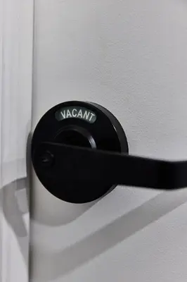 a black door handle on a white door at Capsule Hotel Montreal in Montréal