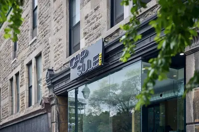 a store sign on the side of a building at Capsule Hotel Montreal in Montréal