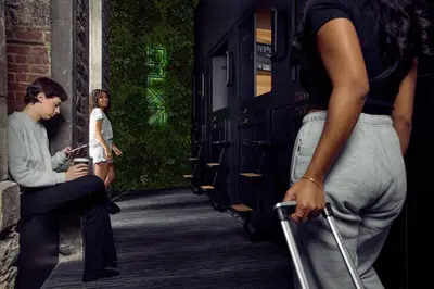 a woman standing next to a woman sitting on a bench at Capsule Hotel Montreal in Montréal
