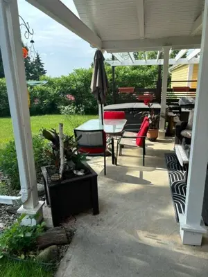 a patio with a table and chairs and an umbrella at Paradise Eastern Township cottage in Cowansville