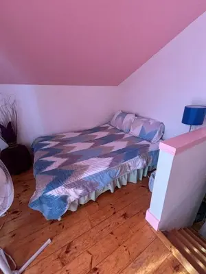 a bedroom with a bed in a room with pink walls at Paradise Eastern Township cottage in Cowansville
