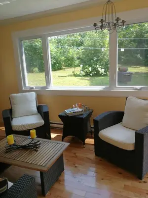 a living room with two chairs and a table and a window at Paradise Eastern Township cottage in Cowansville
