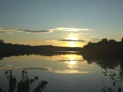 a sunset over a river with the sun setting at Paradise Eastern Township cottage in Cowansville