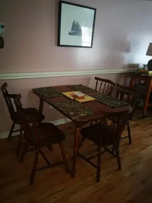 a dining room table with four chairs and a table with at Paradise Eastern Township cottage in Cowansville