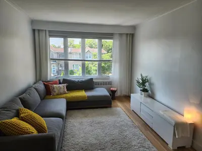 a living room with a couch and a large window at Large & bright 3 bedroom in MTL in Montréal