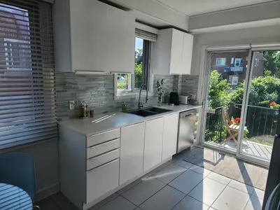 a kitchen with white cabinets and a large window at Large & bright 3 bedroom in MTL in Montréal