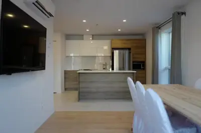 a kitchen with a wooden table and a counter top at Le Bijou Airhome in Montréal