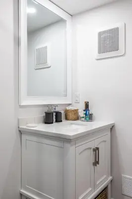 a white bathroom with a sink and a mirror at Tranquille Discret Privé in Laval