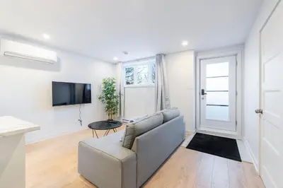 a living room with a couch and a tv at Longueuil New Stylish 3-BDR free parking close to Dix 30&DT in Longueuil