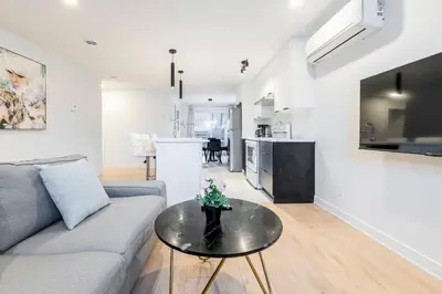 a living room with a couch and a table at Longueuil New Stylish 3-BDR free parking close to Dix 30&DT in Longueuil