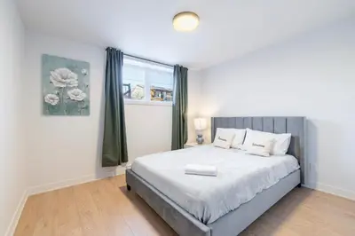 a bedroom with a large bed and a window at Longueuil New Stylish 3-BDR free parking close to Dix 30&DT in Longueuil