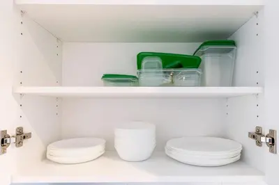 a closet with plates and bowls on shelves at Longueuil New Stylish 3-BDR free parking close to Dix 30&DT in Longueuil