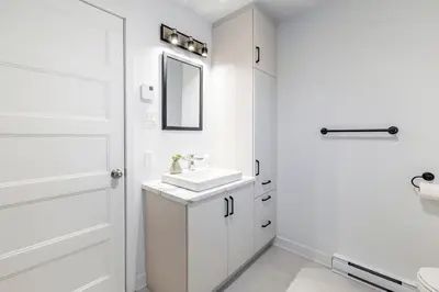 a white bathroom with a sink and a mirror at Longueuil New Stylish 3-BDR free parking close to Dix 30&DT in Longueuil