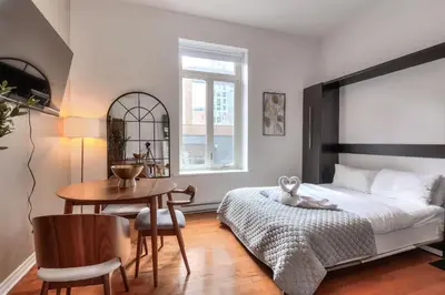 a bedroom with a bed and a desk and a table at Fox Aparthotel 9 min of Palais Des Congres II in Montréal