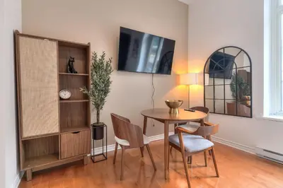 a dining room with a table and chairs and a tv at Fox Aparthotel 9 min of Palais Des Congres II in Montréal