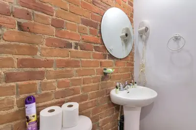 a bathroom with a sink and a brick wall at Fox Aparthotel 9 min of Palais Des Congres II in Montréal