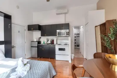 a kitchen with black and white cabinets and a table at Fox Aparthotel 9 min of Palais Des Congres II in Montréal