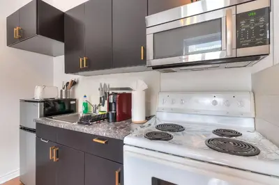 a kitchen with a stove and a microwave at Fox Aparthotel 9 min of Palais Des Congres II in Montréal