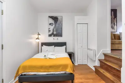 a bedroom with a bed with a yellow blanket at Fox Aparthotel Palais Des Congres III in Montréal