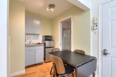 a kitchen with a table and chairs in a room at Fox Aparthotel Palais Des Congres III in Montréal