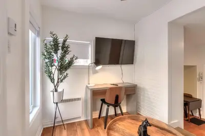 a room with a table and a desk with a plant at Fox Aparthotel Palais Des Congres III in Montréal