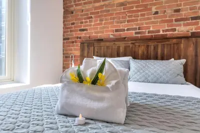 a bed with a pillow with yellow flowers in a bag at Fox Aparthotel Palais Des Congres IV in Montréal
