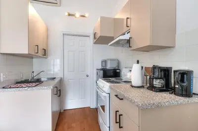 a kitchen with white cabinets and a counter top at Fox Aparthotel Palais Des Congres IV in Montréal