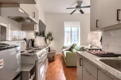 a kitchen with white appliances and a living room at Fox Aparthotel Palais Des Congres IV in Montréal
