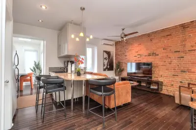 a kitchen and living room with a brick wall at Fox Aparthotel Palais Des Congres VI in Montréal