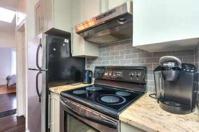 a kitchen with a stove top oven next to a refrigerator at Fox Aparthotel Palais Des Congres VI in Montréal