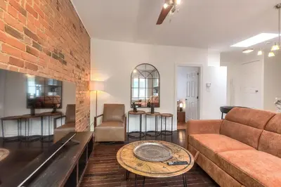 a living room with a couch and a brick wall at Fox Aparthotel Palais Des Congres VI in Montréal