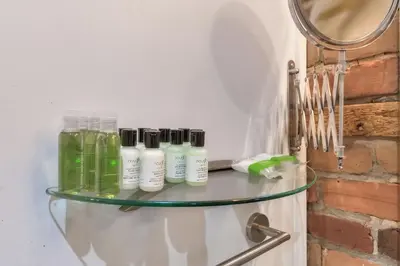 a glass shelf with four bottles on it next to a mirror at Fox Aparthotel Palais Des Congres VI in Montréal