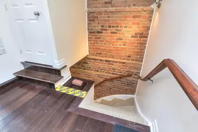 a staircase with a brick wall and a white door at Fox Aparthotel Palais Des Congres VI in Montréal