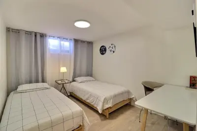 a bedroom with two beds and a table and a window at Private Charming Twin Room & Parking in Saint-Bruno-de-Montarville