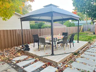 a table and chairs under an umbrella on a deck at Private Charming Twin Room & Parking in Saint-Bruno-de-Montarville